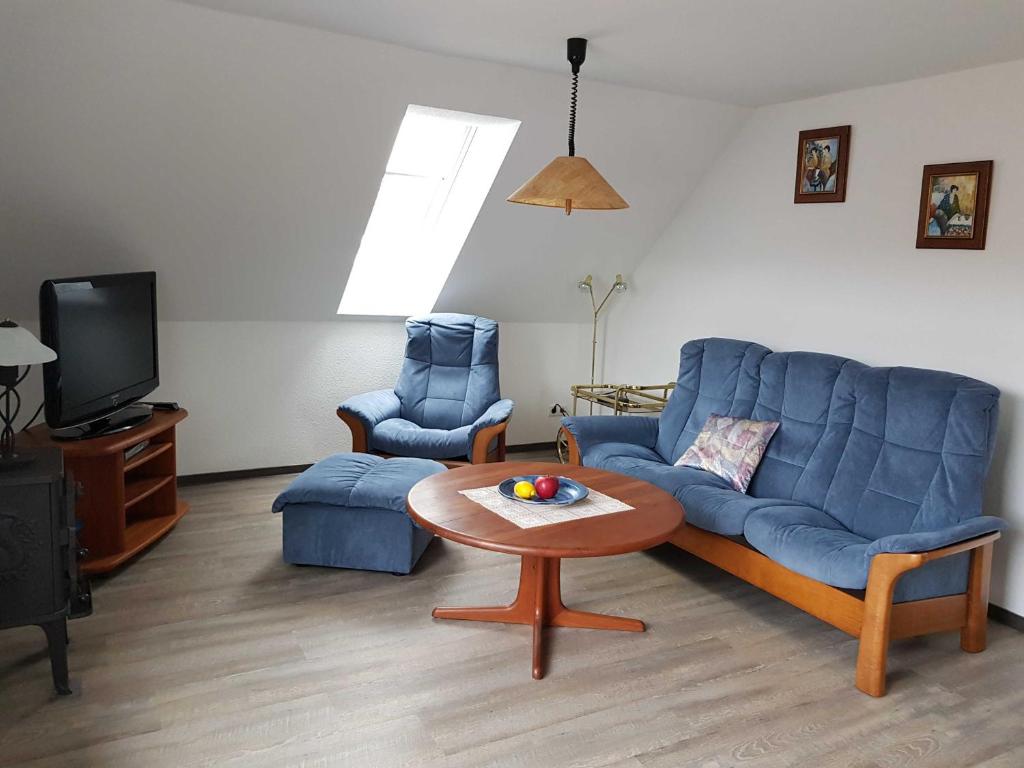 a living room with a blue couch and a table at Ferienwohnung Klütz - Unterkunft mit 2 Schlafzimmern und modernem Bad in Oeversee