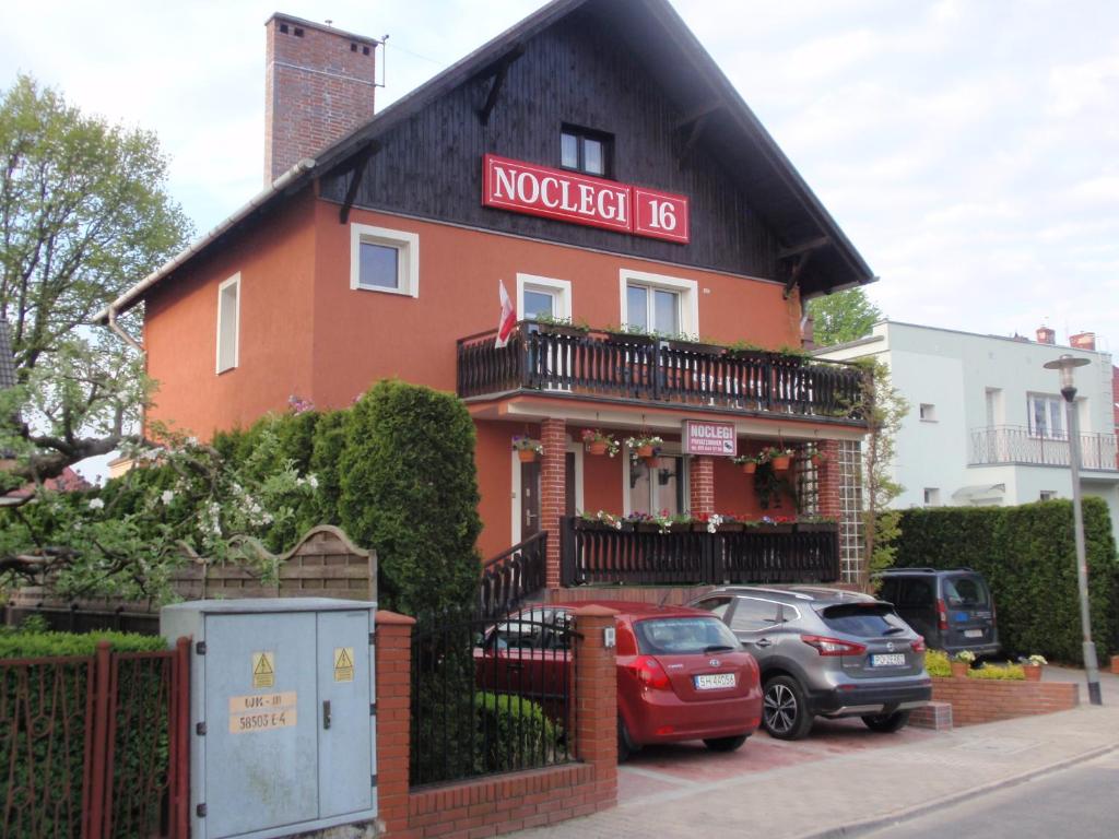 budynek z zaparkowanymi przed nim samochodami w obiekcie Noclegi16 w mieście Bolesławiec