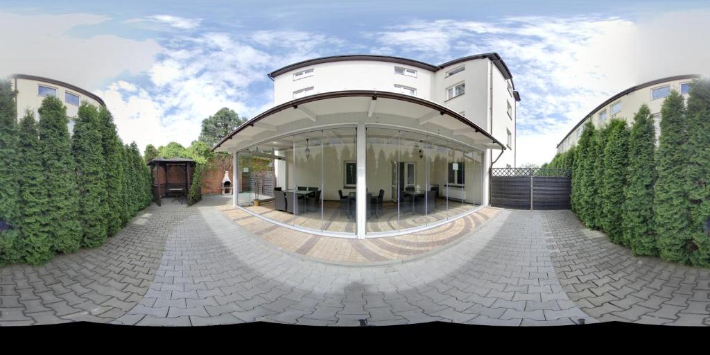 a large white building with a circular driveway at Gościniec Margo in Janki