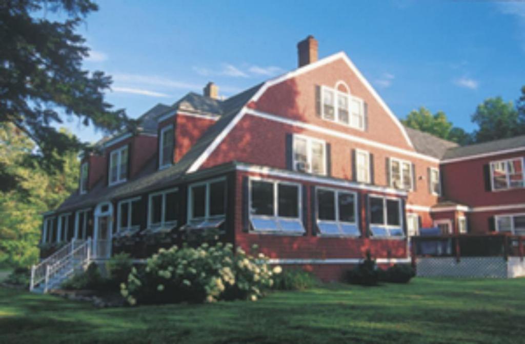 duży dom z czerwonej cegły z zielonym dziedzińcem w obiekcie Inn at Jackson w mieście Jackson