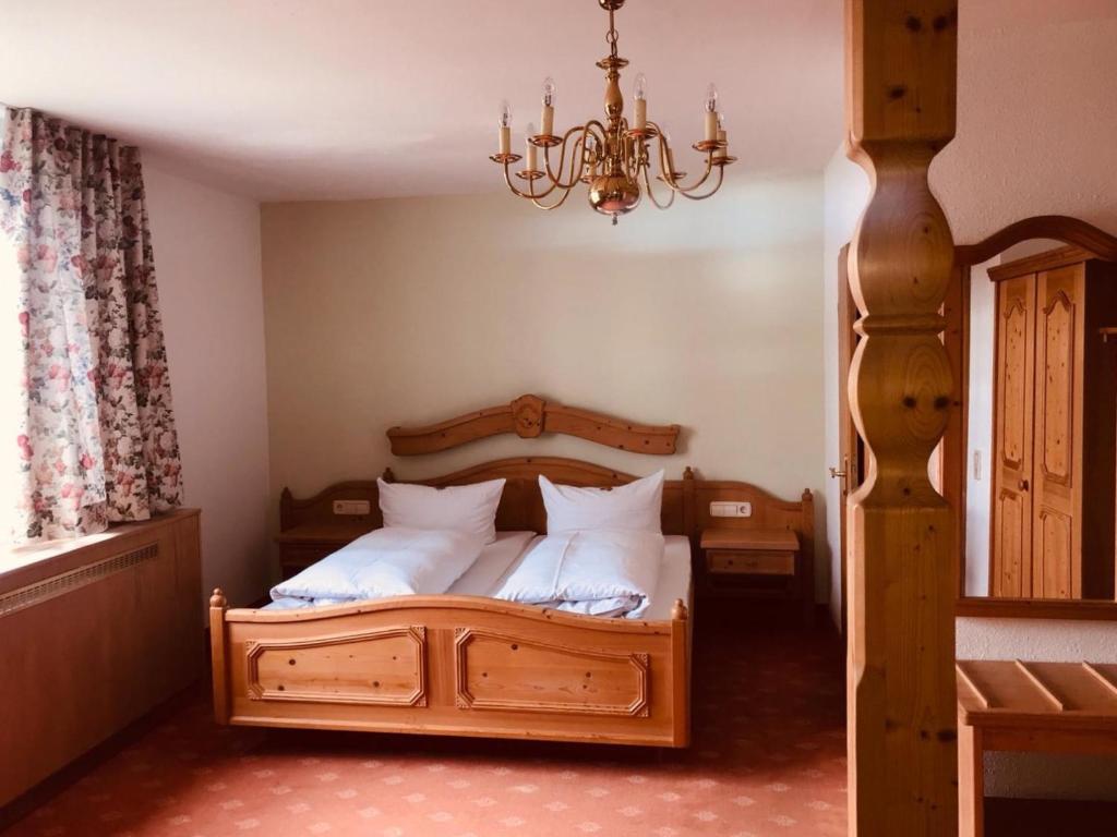 - une chambre avec un lit en bois et des oreillers blancs dans l'établissement Gasthof Hirschen, à Gailingen am Hochrhein