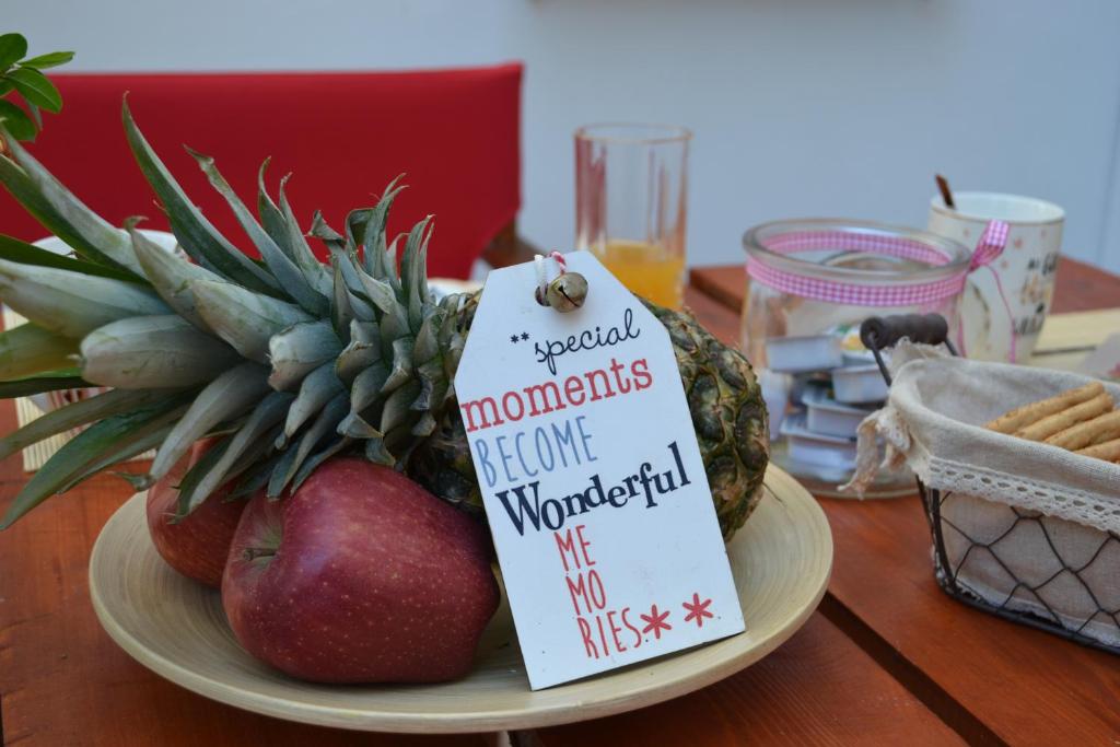 a plate of fruit on a table with a sign at City garden house in Ierapetra