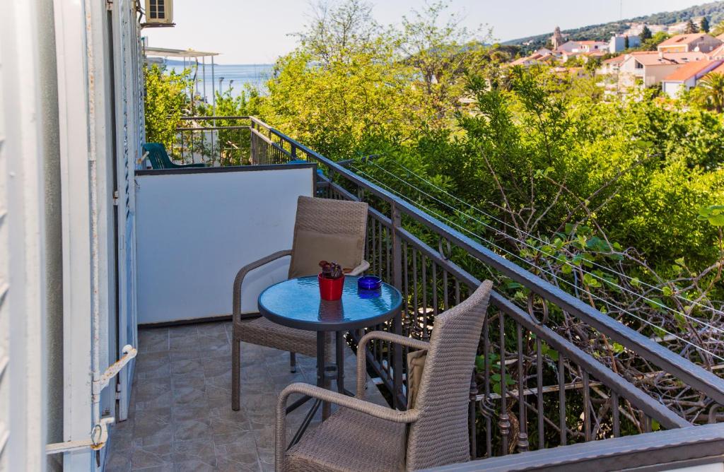 a patio with two chairs and a table on a balcony at Rooms Barbarić in Hvar
