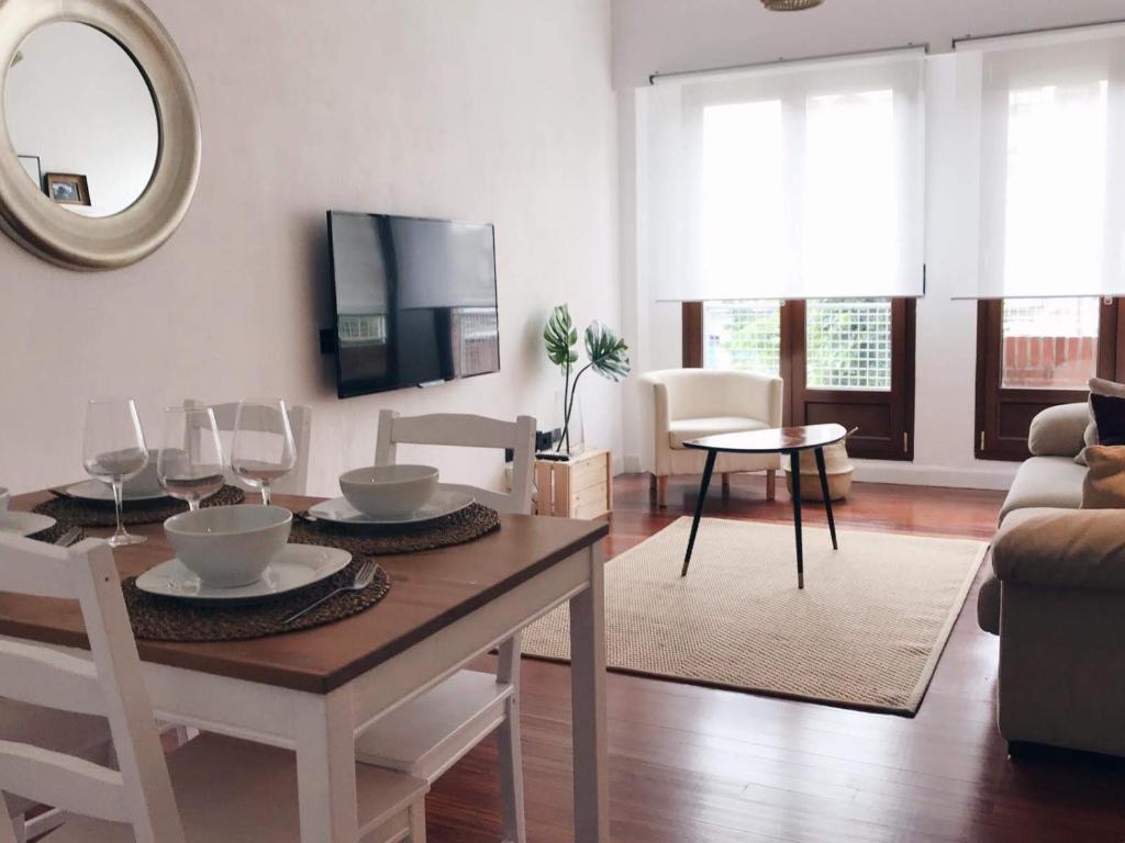 a living room with a table with chairs and a tv at Muy luminoso en San Mamés in Bilbao