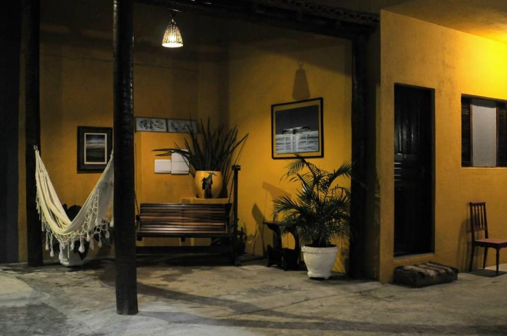 Zimmer mit einer Bank und einer Hängematte in der Unterkunft Guaraú Praia Suítes in Peruíbe