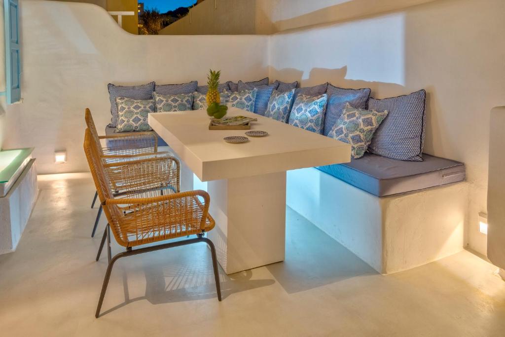 a table and chairs in a room with a couch at Mykonian Mews Luxury Suites in Psarou