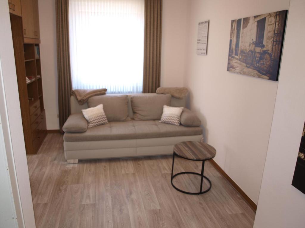 a living room with a couch and a stool at Muttis Apartment in Mönchengladbach