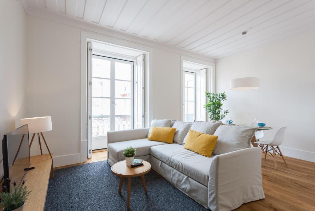 a white living room with a couch and a table at FLH Restauradores Fantastic Flat in Lisbon