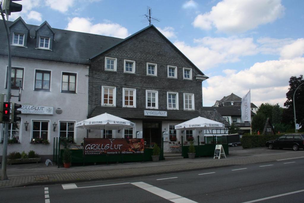 ein großes Gebäude mit weißen Sonnenschirmen davor in der Unterkunft Grillglut in Arnsberg