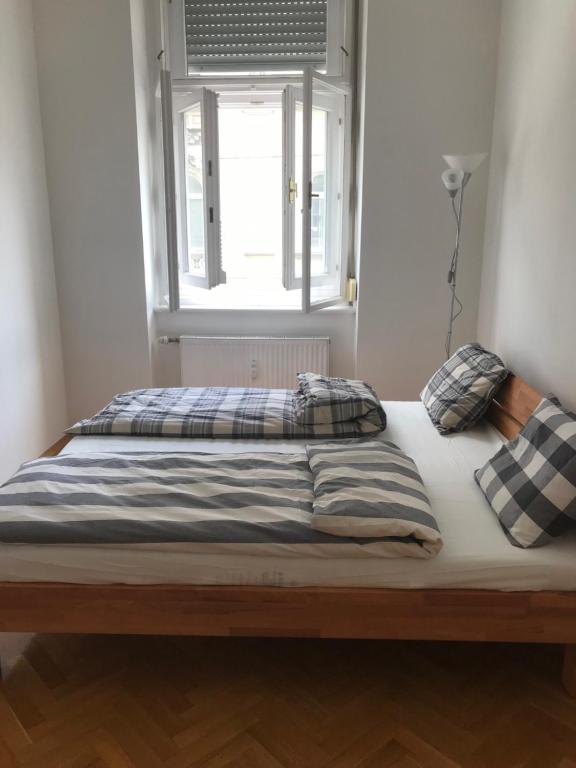 uma cama num quarto com uma janela em Lilians modern Appartement in historical Citycenter em Graz