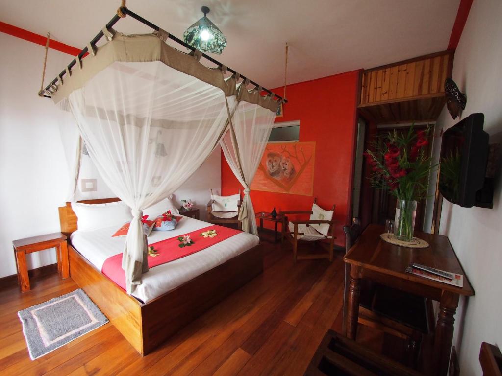 a bedroom with a bed with a canopy at Gassy Country House in Ivato