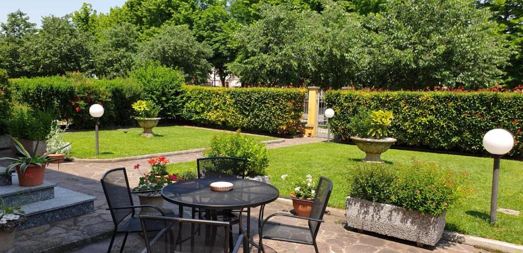 a patio with a table and chairs in a garden at La Casa di Tino in Fontanellato