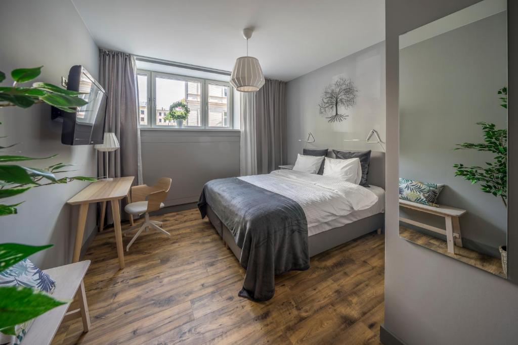 a bedroom with a bed and a desk and a table at Hotel Saida - quality hostel in Riga