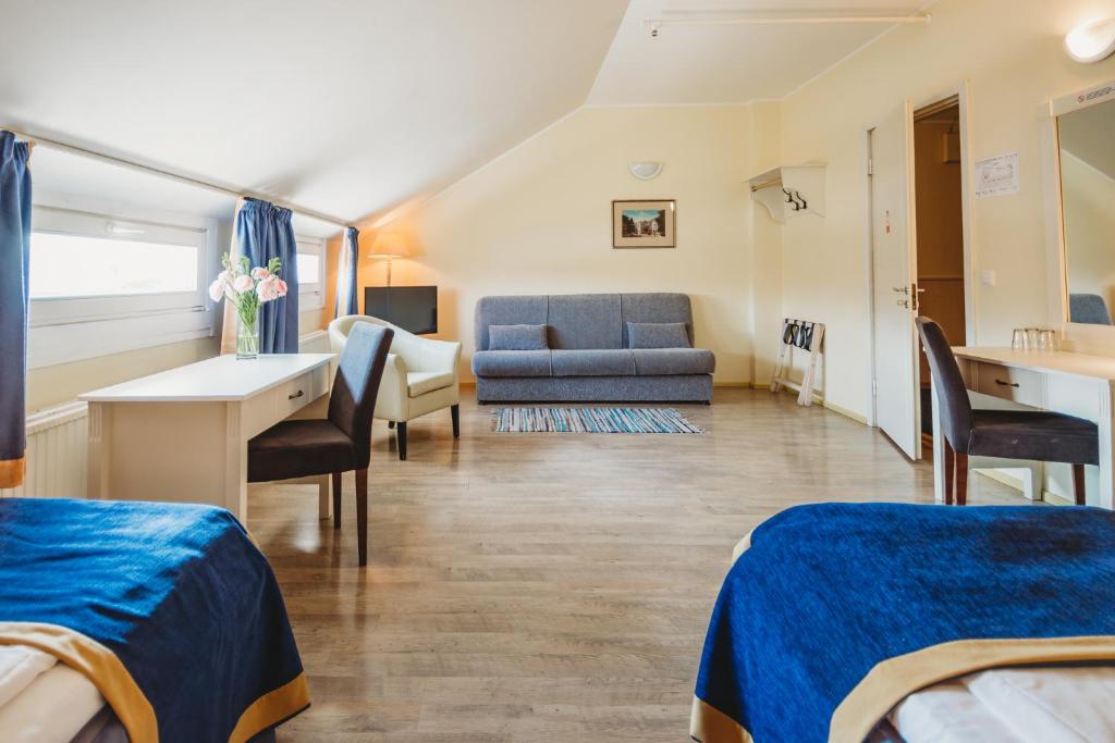 Cette chambre comprend deux lits, un bureau et un canapé. dans l'établissement Economy Hotel, à Tallinn