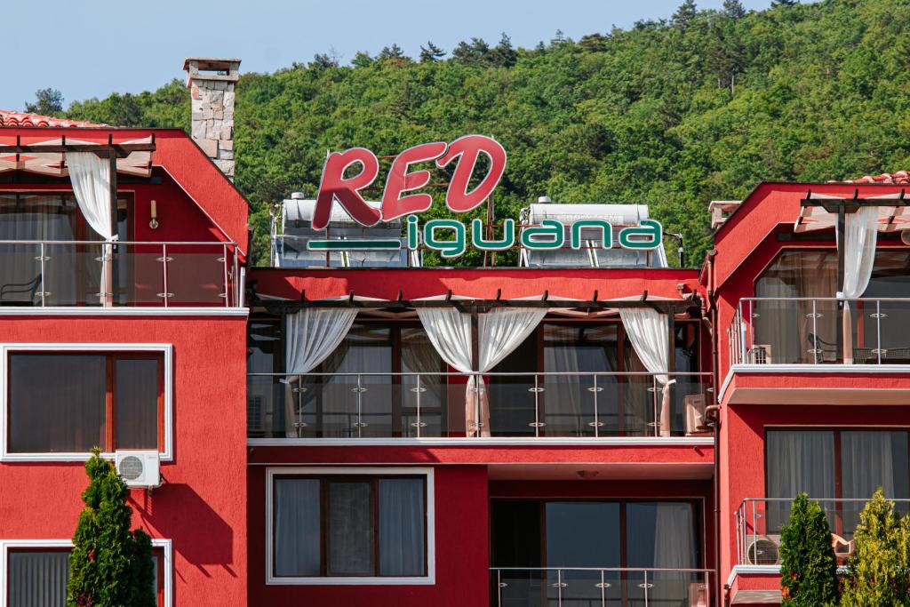 un edificio rojo con un cartel encima en Red Iguana Hotel, en Sveti Vlas