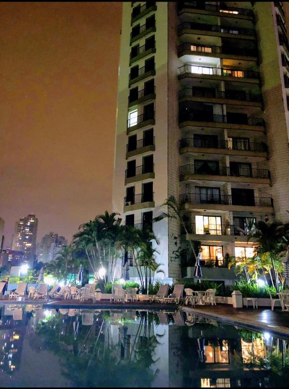 a large building with a pool in front of a building at Apartamento Top Morumbi in São Paulo