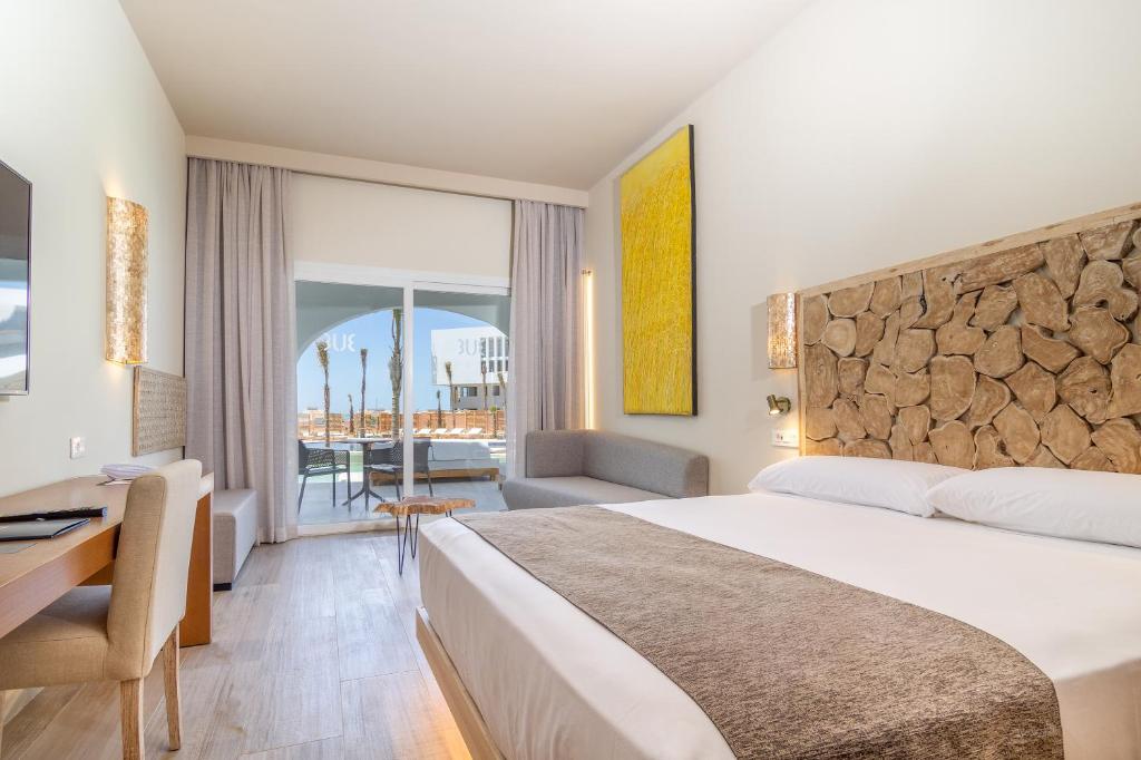 サアラ・デ・ロス・アトゥネスにあるZahara Beach & Spa by QHotels - Adults Recommendedの大きなベッドと机があるホテルの部屋