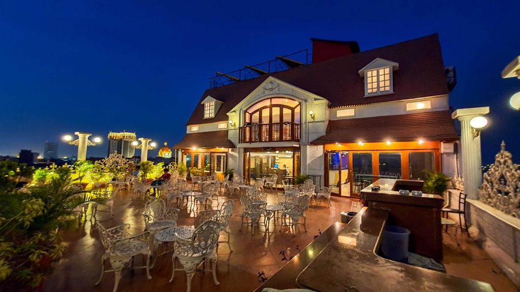 a building with tables and chairs in front of it at Hotel Godwin - Colaba in Mumbai