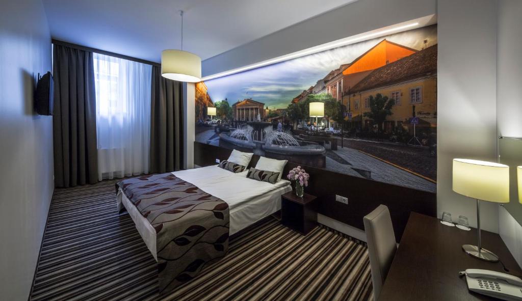 فندق فيلنيوس سيتي في فيلنيوس: غرفة نوم بسرير ودهان على الحائط