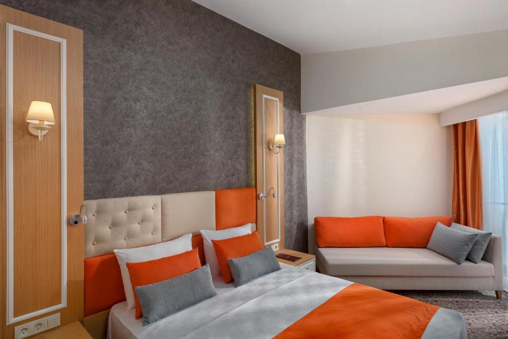 a bedroom with a bed and a couch at Golden Orange Hotel in Antalya