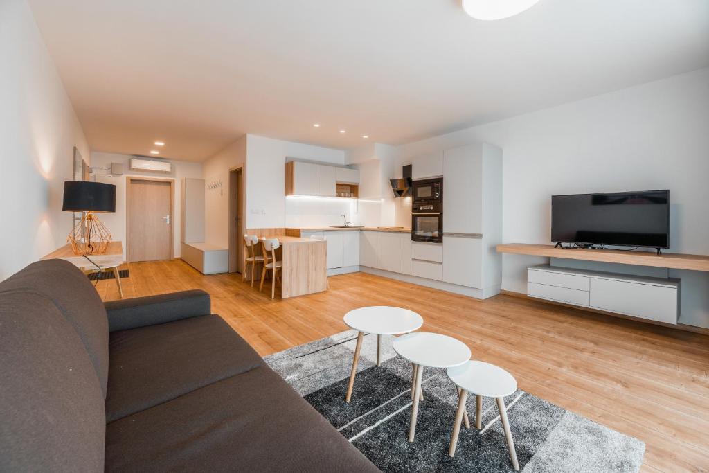 sala de estar con sofá, mesas y cocina en Apartmány pri vstupe do Aquaparku, en Senec