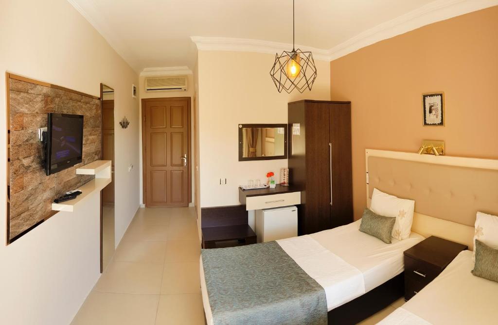 a hotel room with a bed and a tv at Papirus Hotel in Adrasan