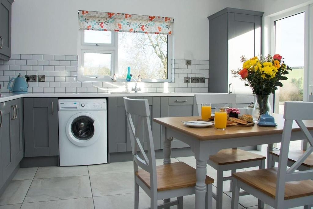 a kitchen with a table and a washing machine at Bramble Cottage in Rathfriland