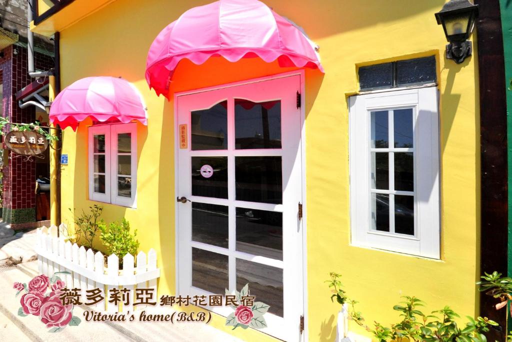 a house that is painted yellow and pink at Vitoria Country Garden in Xiaoliuqiu