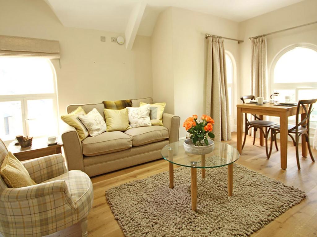 sala de estar con sofá y mesa en Harlech Apartments - Matholwch en Harlech