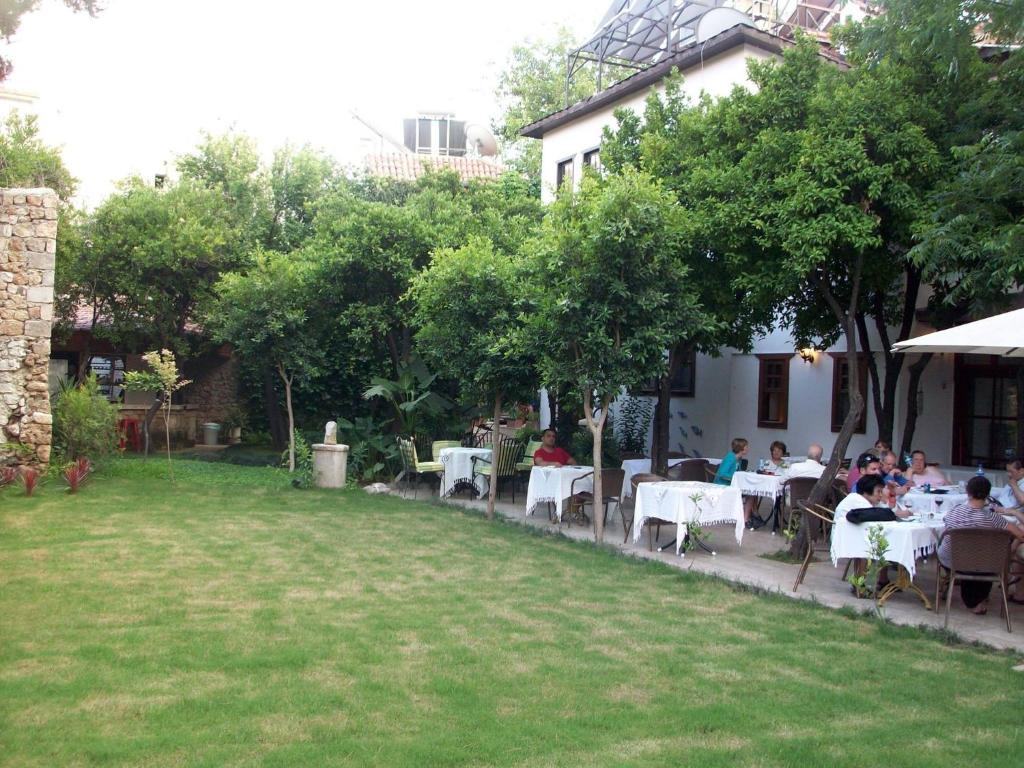 a group of people sitting at tables in a garden at The Ninova in Antalya