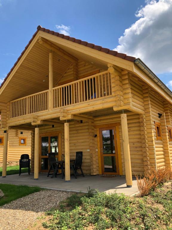 a log cabin with a porch and a deck at Boomstamhuis High Chaparral in Oorsbeek