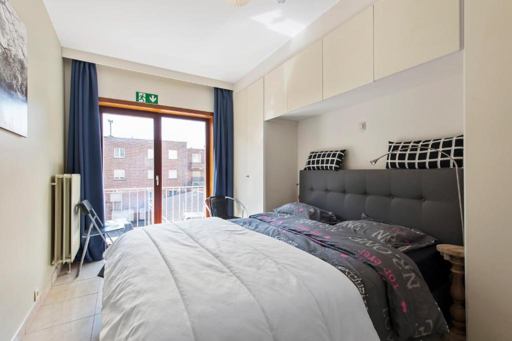 - une chambre avec un grand lit et une fenêtre dans l'établissement Zeewende 1A, à Zeebruges