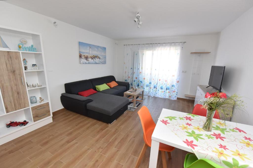 a living room with a black couch and a table at Apartman MiR in Šibenik