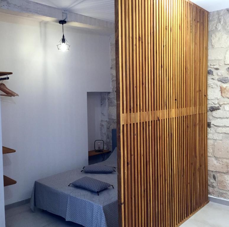 a bedroom with a bed and a wooden wall at Studio climatisé, La Cloison in Arles