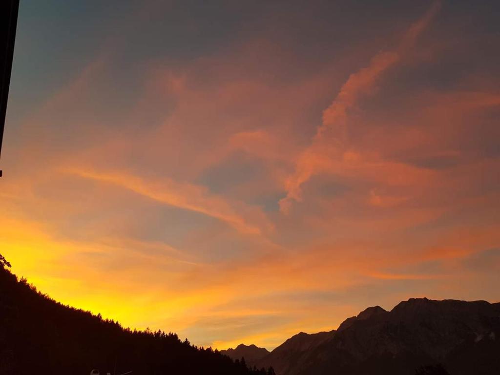 a sunset in the mountains with a sky at Apartement Klingenschmid in Volders