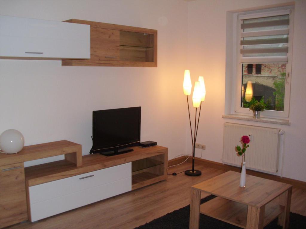 Gästewohnung in Döbeln في دوبلن: غرفة معيشة مع تلفزيون وطاولة