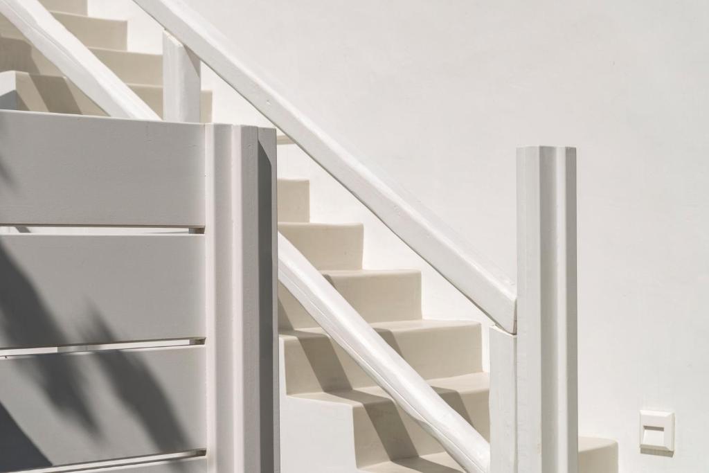 a white staircase with a refrigerator next to a stair case at Mykonian Mews Luxury Suites in Psarou