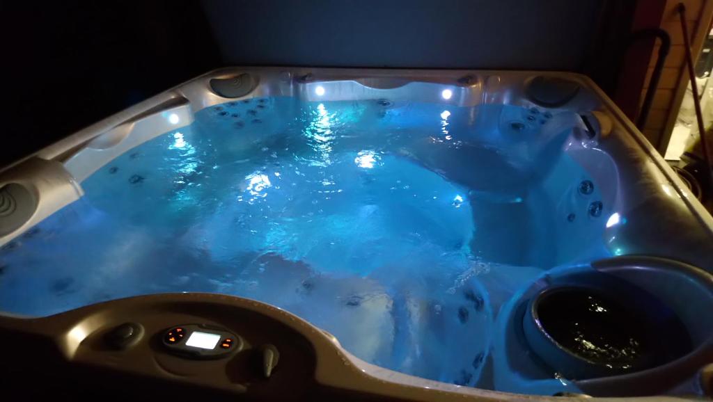 een bad met een blauwe vloeistof erin bij ENTRE LOIRE ET CHER "Les Bruyères" Gîte & SPA Privatif in Tour-en-Sologne