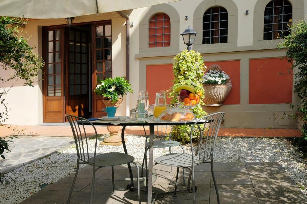 a table and chairs in a courtyard with a house at Villa il Leone in Florence