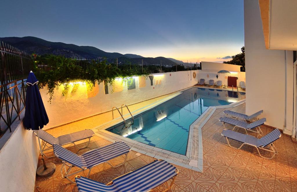 a swimming pool with two chairs and avisorvisor at Selena View Studios in Malia