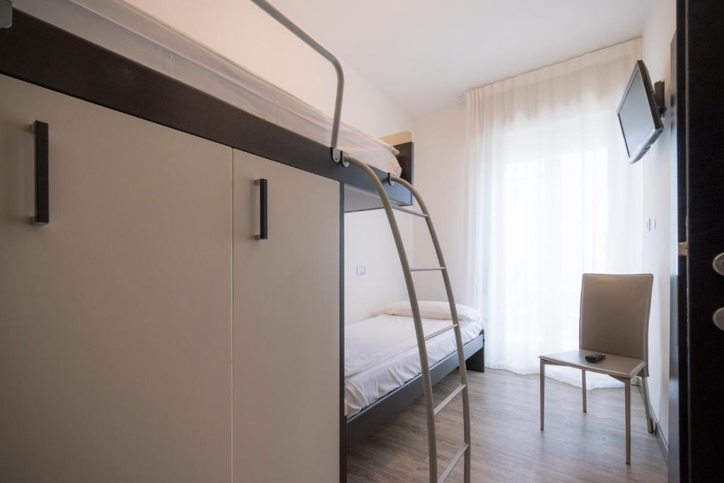 a bedroom with a bunk bed and a ladder at Hotel Bristol in Caorle