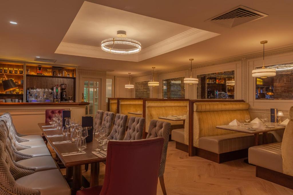 a restaurant with tables and chairs and a bar at Glenroyal Hotel in Maynooth
