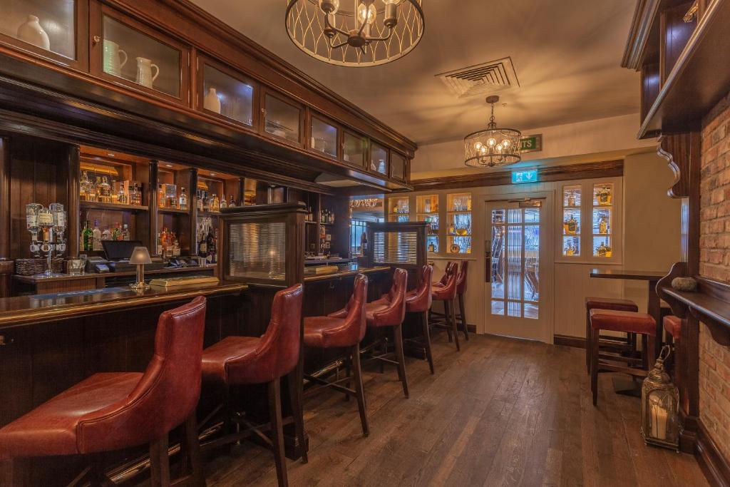 a bar with a row of stools in a pub at Glenroyal Hotel in Maynooth