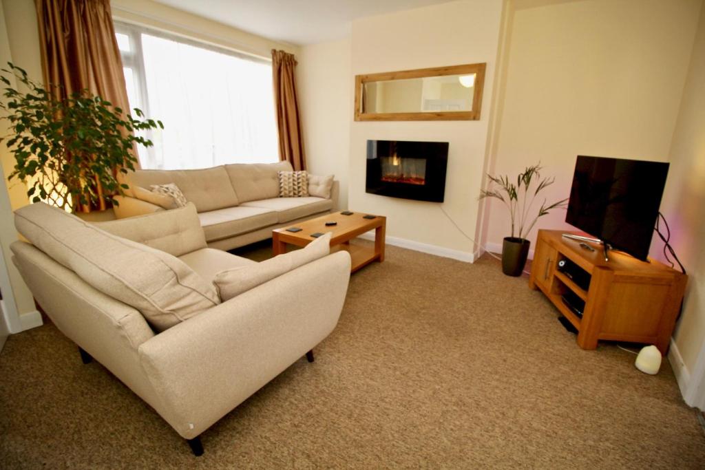 a living room with a couch and a tv at Henry's Guesthouse in Bath