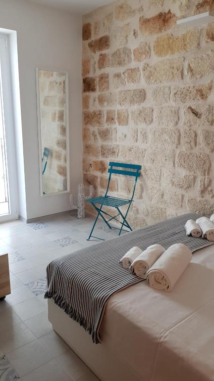 een groot bed in een kamer met een bakstenen muur bij Nisea in Polignano a Mare