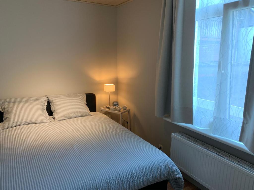 um pequeno quarto com uma cama e uma janela em Vakantiehuis Babelle 2 em Blankenberge