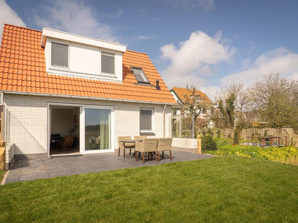 Casa con patio con mesa y sillas en fantastic bungalow on Texel en De Cocksdorp