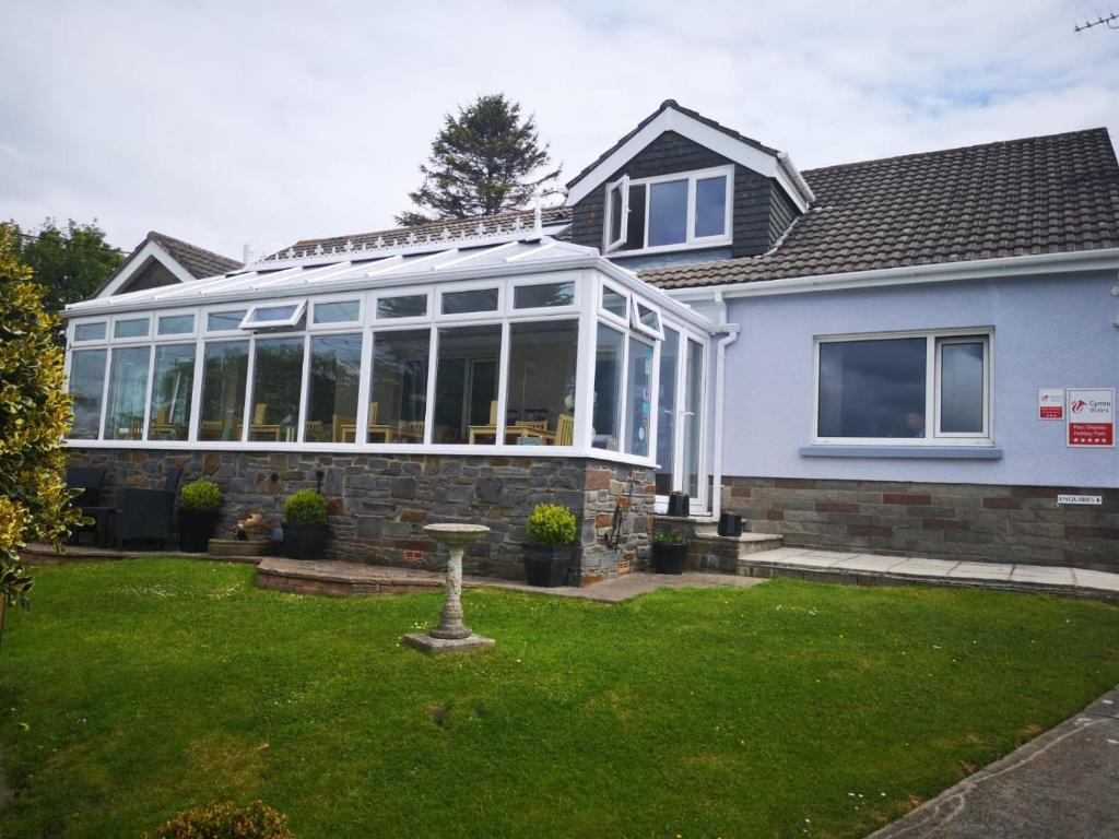 a house with a conservatory on top of it at Pinewood B&B in Saundersfoot