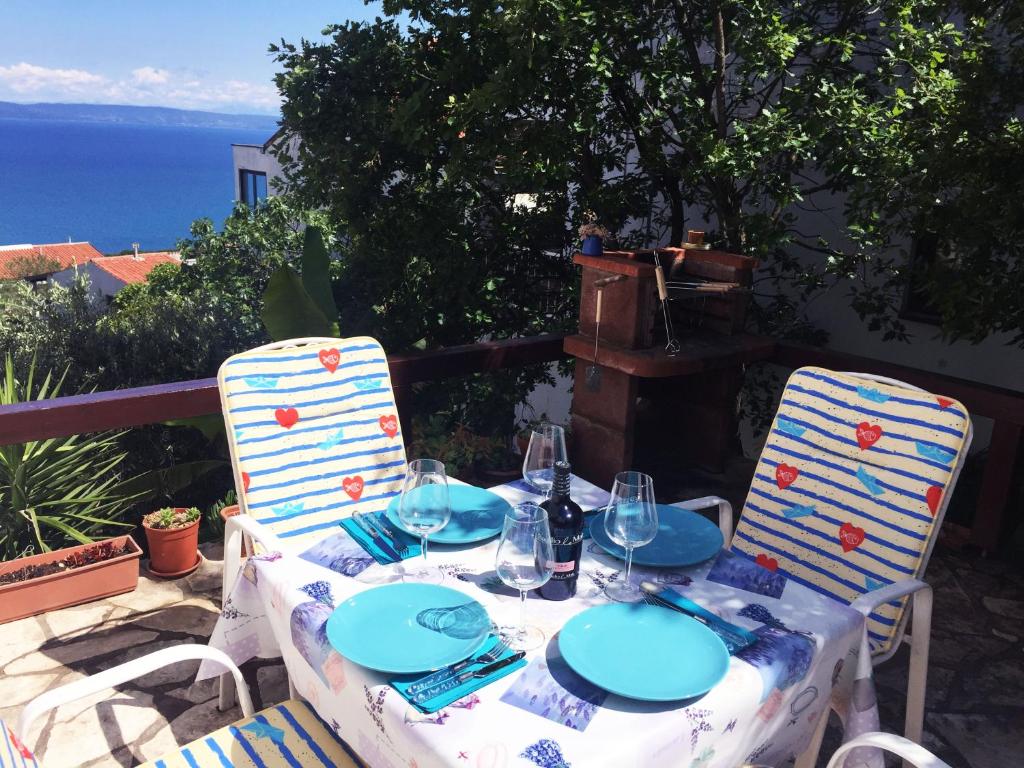 a table with plates and glasses on top of it at Lovely studio apartment Mare e Sole in Labin