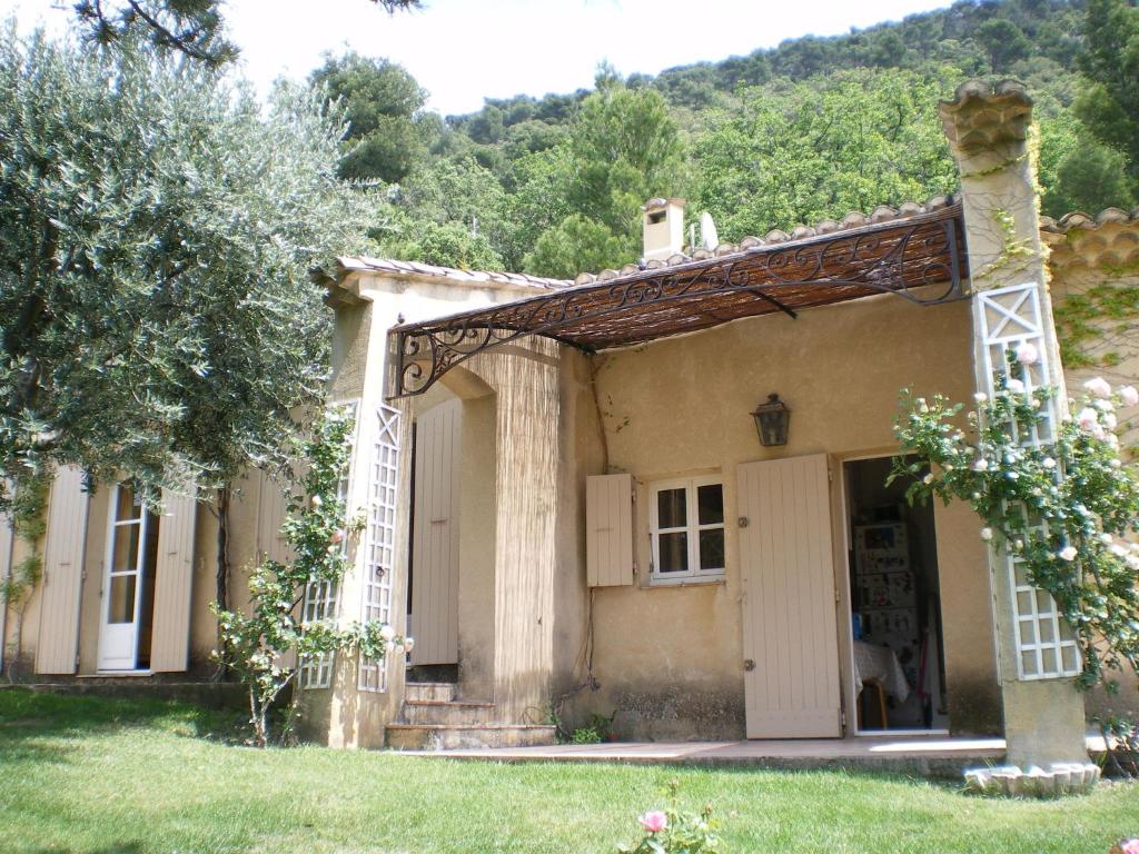 an old house in a yard with a tree at Sunny holiday home in Provence with pool in Séguret